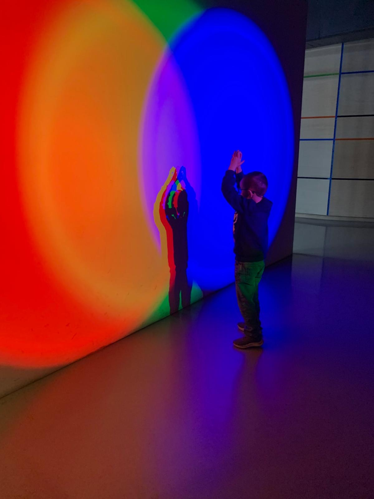 A child enjoying the colour display on the wall in the museum.