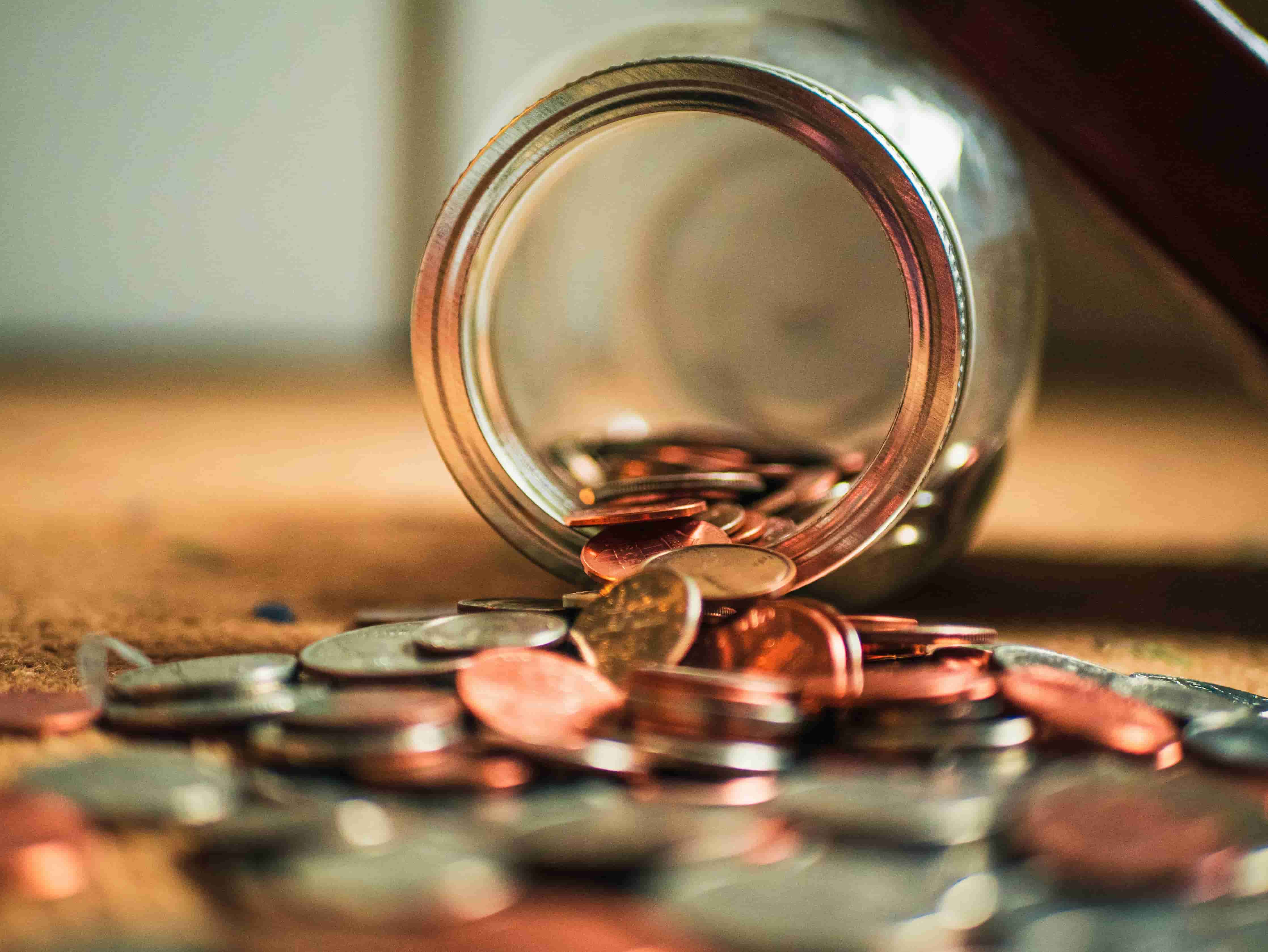  A jar on its side with coins spilled out.