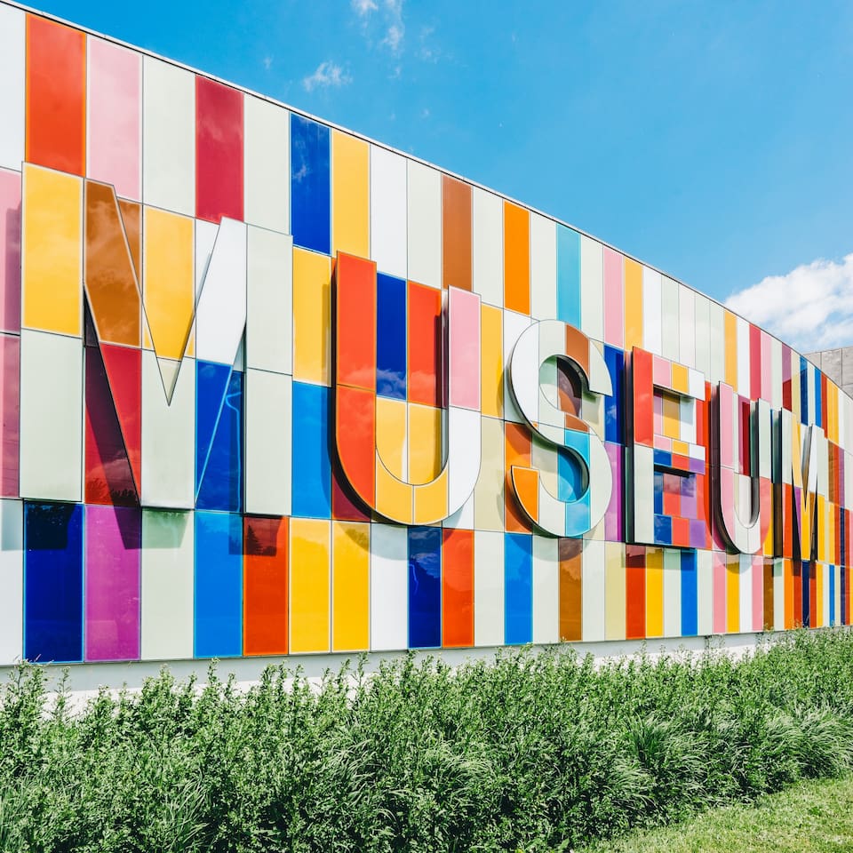 Giant colorful mosacic style wall spelling out the word 'Museum'.