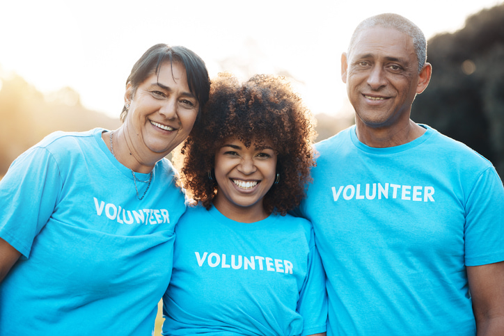 3 volunteers, wearing blue volunteer t-shirts.