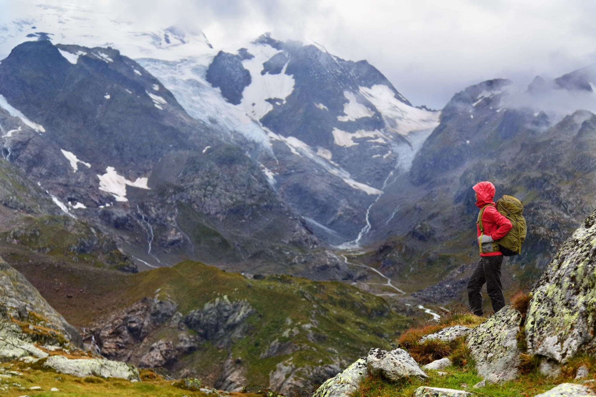 Person in a red jacket hiking in the mountains.
